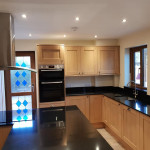 Wooden kitchen with black worktops