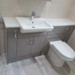 Grey bathroom unit with built in sink and toilet
